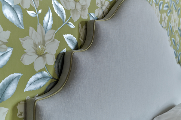 Ornate Curved Shape Cardigan Headboard upholstered in House Linen Mineral Blue Fabric with Contrast Piping in Linen Kiwi in a Jardin Des Plantes Green and White Floral Wallpapered Room