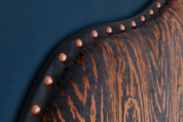 Pointed Teardrop Curved Style Ewe Headboard upholstered in Kai Marva Copper with a Frame Border in Flat Velvet Anthracite with Giant Copper Nails in a Farrow & Ball Hague Blue painted room
